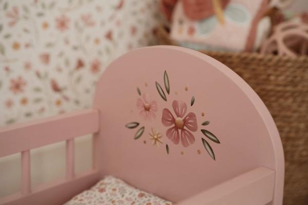 Puppenbett mit weicher Bettwäsche im floralen Design