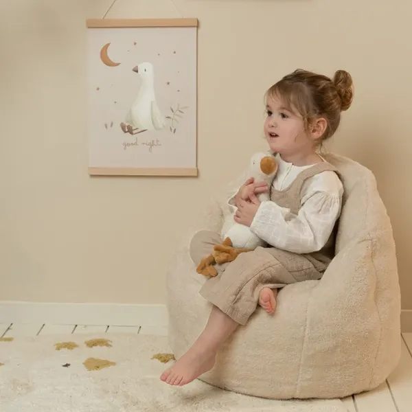 Kleinkind sitzt auf weichem Little Dutch Sessel in Beige