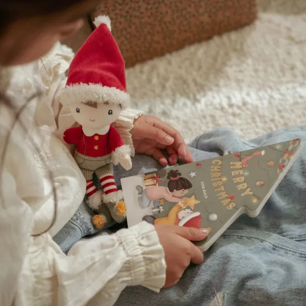 Kuscheltier Jim sitzt vor dem Weihnachtsbuch